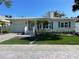 Updated Florida home with a light-colored exterior, landscaping, and driveway at 1041 Eldorado Ave, Clearwater Beach, FL 33767