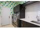 Laundry room with modern washer and dryer, quartz countertop, and stylish floral wallpaper at 110 Deerpath Dr, Oldsmar, FL 34677