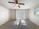 Bright bedroom with carpet, ceiling fan, and sliding glass doors to deck at 1116 E Boyer St, Tarpon Springs, FL 34689