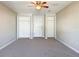 Spacious bedroom with ceiling fan, carpet, and multiple closets at 1116 E Boyer St, Tarpon Springs, FL 34689