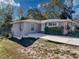 Updated home with a concrete driveway and side yard at 1116 E Boyer St, Tarpon Springs, FL 34689