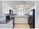 Modern kitchen, white cabinets, granite countertops, black appliances at 1116 E Boyer St, Tarpon Springs, FL 34689