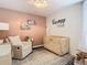 Bedroom featuring crib, armchair, and custom wall art at 11616 Crest Creek Dr, Riverview, FL 33569