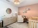 Bright Bedroom with crib, dresser, and accent wall at 11616 Crest Creek Dr, Riverview, FL 33569