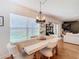 White dining table with a chandelier and view to the living room at 11616 Crest Creek Dr, Riverview, FL 33569