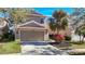 Two-story house with a tan exterior, two-car garage, and landscaped yard at 11616 Crest Creek Dr, Riverview, FL 33569
