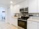 White kitchen with stainless steel appliances and tile backsplash at 11616 Crest Creek Dr, Riverview, FL 33569