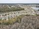 Aerial view showcasing a neighborhood of houses near a lake and lush trees at 13456 Marble Sands Ct, Hudson, FL 34669