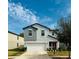 Two-story house with gray siding, white garage door, and landscaping at 13456 Marble Sands Ct, Hudson, FL 34669
