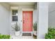 Modern coral front door with potted plants at 13456 Marble Sands Ct, Hudson, FL 34669