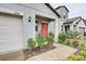 Charming front porch with a red door, lantern lighting and meticulous landscaping at 13456 Marble Sands Ct, Hudson, FL 34669