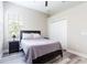 Bright bedroom with a queen bed, nightstand, and double door closet at 13540 Knotty Ln, Hudson, FL 34669