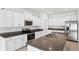 Modern kitchen with white cabinets, granite counters, and stainless steel appliances at 13580 Willow Bluestar Loop, Riverview, FL 33579