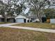 House exterior with a grey garage door and green landscaping at 1412 Columbia Ave, Palm Harbor, FL 34683