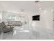 Bright living room features a sectional sofa, marble floors, and large TV at 15214 Octavia Ln, Odessa, FL 33556