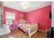 bedroom with white crib and pink walls at 17071 Oval Rum Dr, Wimauma, FL 33598