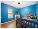 bedroom with gray crib and blue walls at 17071 Oval Rum Dr, Wimauma, FL 33598