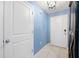 Bright entryway with light blue walls, tile flooring, and white doors at 17071 Oval Rum Dr, Wimauma, FL 33598