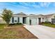 Single-story house with gray exterior, landscaping, and a two-car garage at 17071 Oval Rum Dr, Wimauma, FL 33598