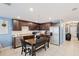 Open concept kitchen with dark cabinetry, granite countertops, and stainless steel appliances at 17071 Oval Rum Dr, Wimauma, FL 33598
