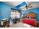 Bright bedroom with blue walls, a ceiling fan, and a wooden bed frame at 17852 Fancy Ln, Hudson, FL 34667