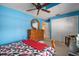 Bedroom with blue walls, ceiling fan, and double door closet at 17852 Fancy Ln, Hudson, FL 34667