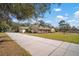 Long driveway leading to a ranch-style home with a landscaped yard at 17852 Fancy Ln, Hudson, FL 34667