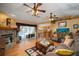 Bright living room with a stone fireplace, hardwood floors, and pool view at 17852 Fancy Ln, Hudson, FL 34667