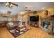 Cozy living room with a stone fireplace, hardwood floors, and pool view at 17852 Fancy Ln, Hudson, FL 34667