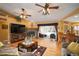 Spacious living room with a stone fireplace, hardwood floors, and access to the pool area at 17852 Fancy Ln, Hudson, FL 34667