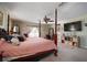 Main bedroom with a large TV, and a four poster bed at 17852 Fancy Ln, Hudson, FL 34667