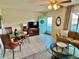 Living room featuring a seating area, dining table, and teal door at 2042 Australia W Way # 78, Clearwater, FL 33763