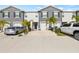 Two story townhome with gray siding, two car garage, and palm trees at 34395 Sorrel Mint Dr, Wesley Chapel, FL 33543