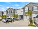 Two story townhome with gray siding, two car garage, and palm trees at 34395 Sorrel Mint Dr, Wesley Chapel, FL 33543