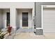 Modern front door with a gray frame and a small entry way at 34395 Sorrel Mint Dr, Wesley Chapel, FL 33543