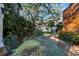 Private backyard with metal table and chairs, lush landscaping and brick flooring at 4307 W Kensington Ave, Tampa, FL 33629