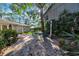 Landscaped backyard with brick patio, metal table and chairs and lush foliage at 4307 W Kensington Ave, Tampa, FL 33629