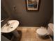 Small half bathroom with pedestal sink, toilet, and beige tile floor at 4713 Jennings Bay Ct, Tampa, FL 33611