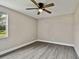 Spacious bedroom with ceiling fan, large window, and grey flooring at 516 Highview N Cir, Brandon, FL 33510