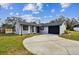 Updated home exterior featuring gray paint, black garage door, and a spacious yard at 516 Highview N Cir, Brandon, FL 33510