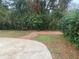 Large backyard with brick pathway and mature trees, and partially covered by a patio at 6919 Greenhill Pl, Tampa, FL 33617