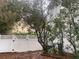 Fenced backyard with mature trees and green bushes, creating a private outdoor space at 6919 Greenhill Pl, Tampa, FL 33617