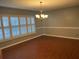 Empty dining room featuring hardwood floors, plantation shutters and modern lighting fixture at 6919 Greenhill Pl, Tampa, FL 33617