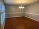 Spacious dining room featuring hardwood floors, plantation shutters and modern lighting fixture at 6919 Greenhill Pl, Tampa, FL 33617