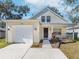 Charming light yellow house with a white garage and porch at 6927 Summer Harbor Ln, Riverview, FL 33578