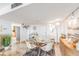 Modern dining area features a glass table and four beige chairs, stylish decor, and a view into the kitchen at 7 Elgin Pl # 401, Dunedin, FL 34698