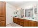 Bathroom with double vanity, wood cabinets, and a large mirror at 7312 7Th Nw Ave, Bradenton, FL 34209