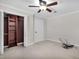 Bright bedroom with ceiling fan, built-in shelving, and tile floors at 10228 Oslin St, Tampa, FL 33615