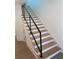 Modern staircase with light wood steps and metal railing at 1046 Bass Blvd, Dunedin, FL 34698