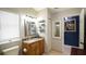 Bathroom with granite vanity, wood cabinets, and a blue accent wall at 10745 Bardes Ct, Seminole, FL 33777